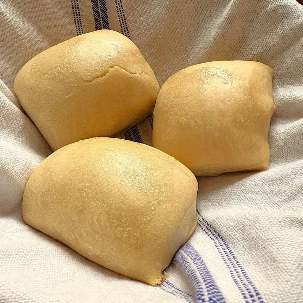 sourdough rolls on a white kitchen towel