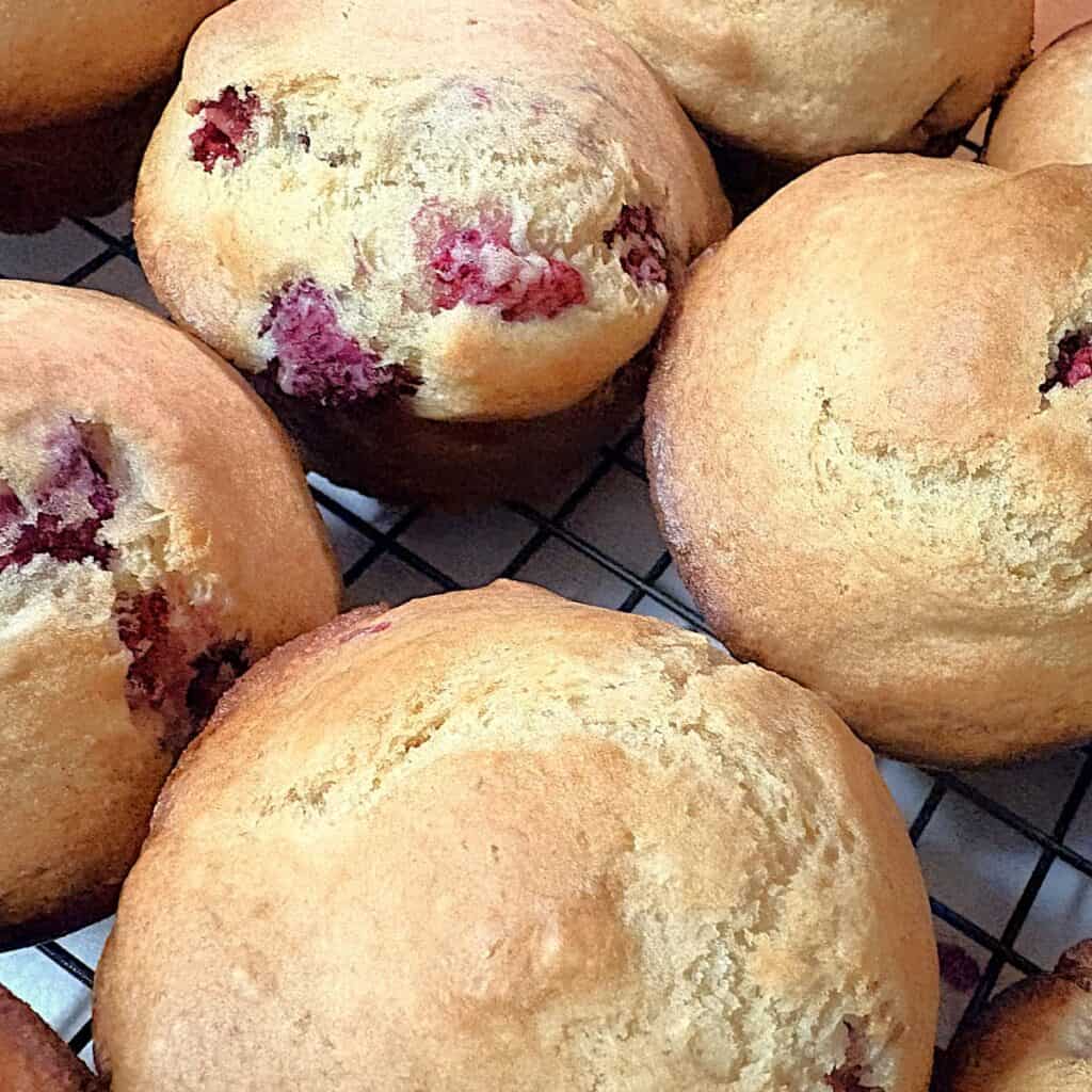 sourdough raspberry muffins on a wire cooling rack