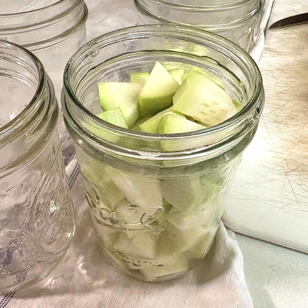 chopped, peeled zucchini in a glass pint jar