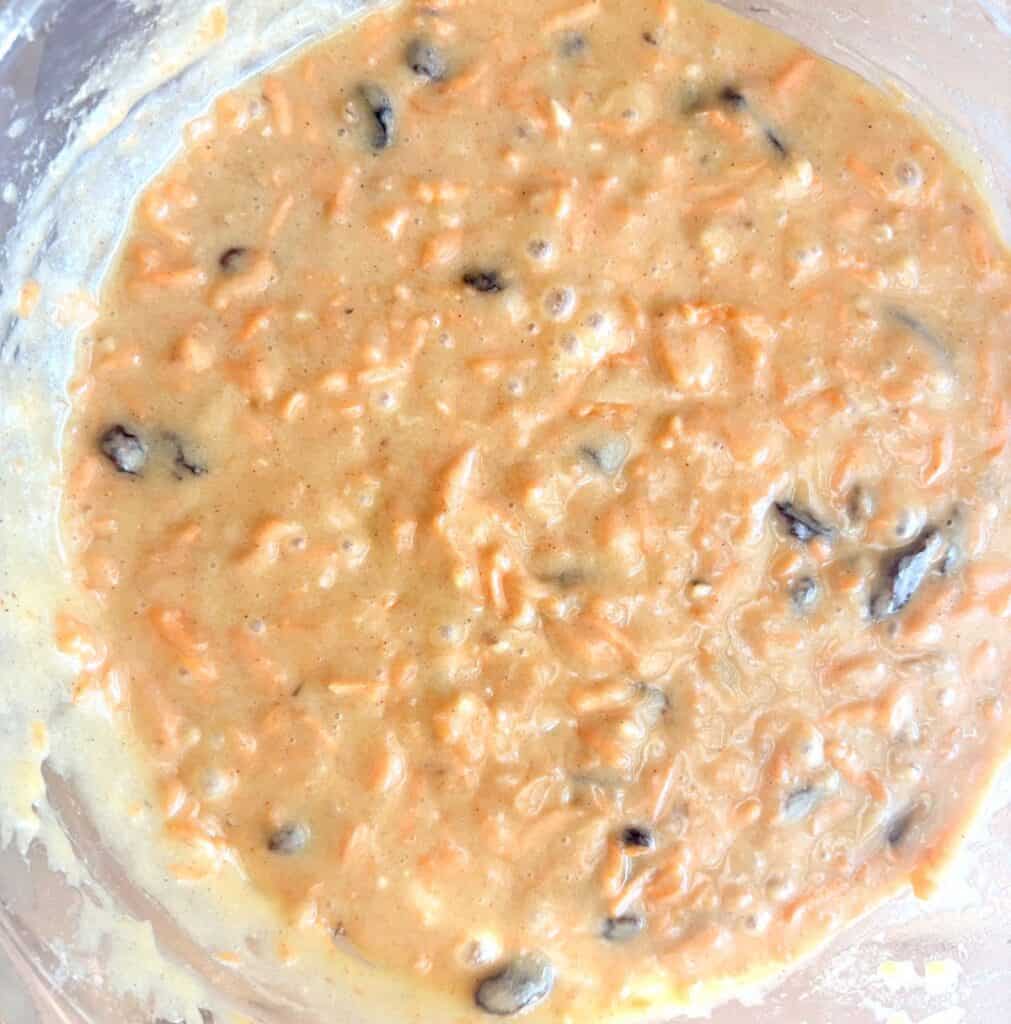 carrot walnut cake batter in a glass bowl
