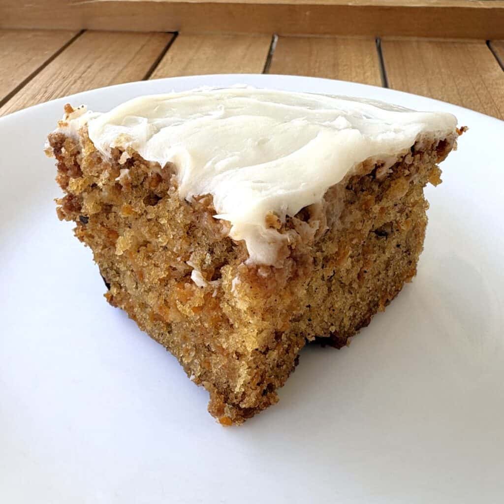 a slice of carrot walnut cake sitting on a white plate